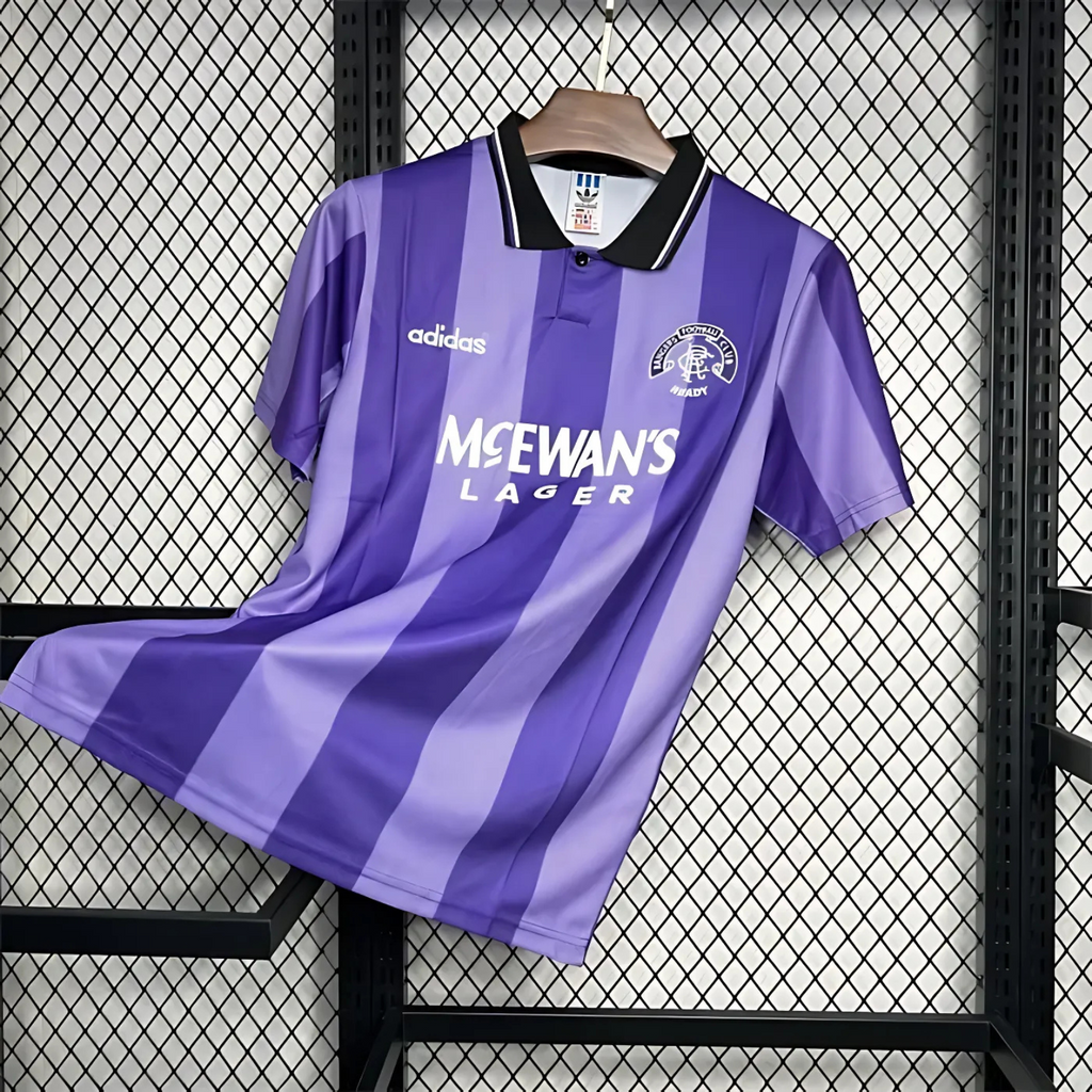 Striped Purple Rangers FC away sports jersey from 1994/95 with Adidas logo and McEwan's Lager text on a hanger against a grid background.