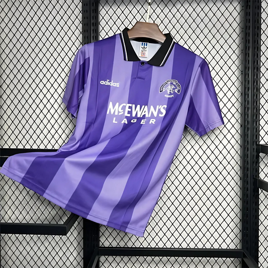 Striped Purple Rangers FC away sports jersey from 1994/95 with Adidas logo and McEwan's Lager text on a hanger against a grid background.