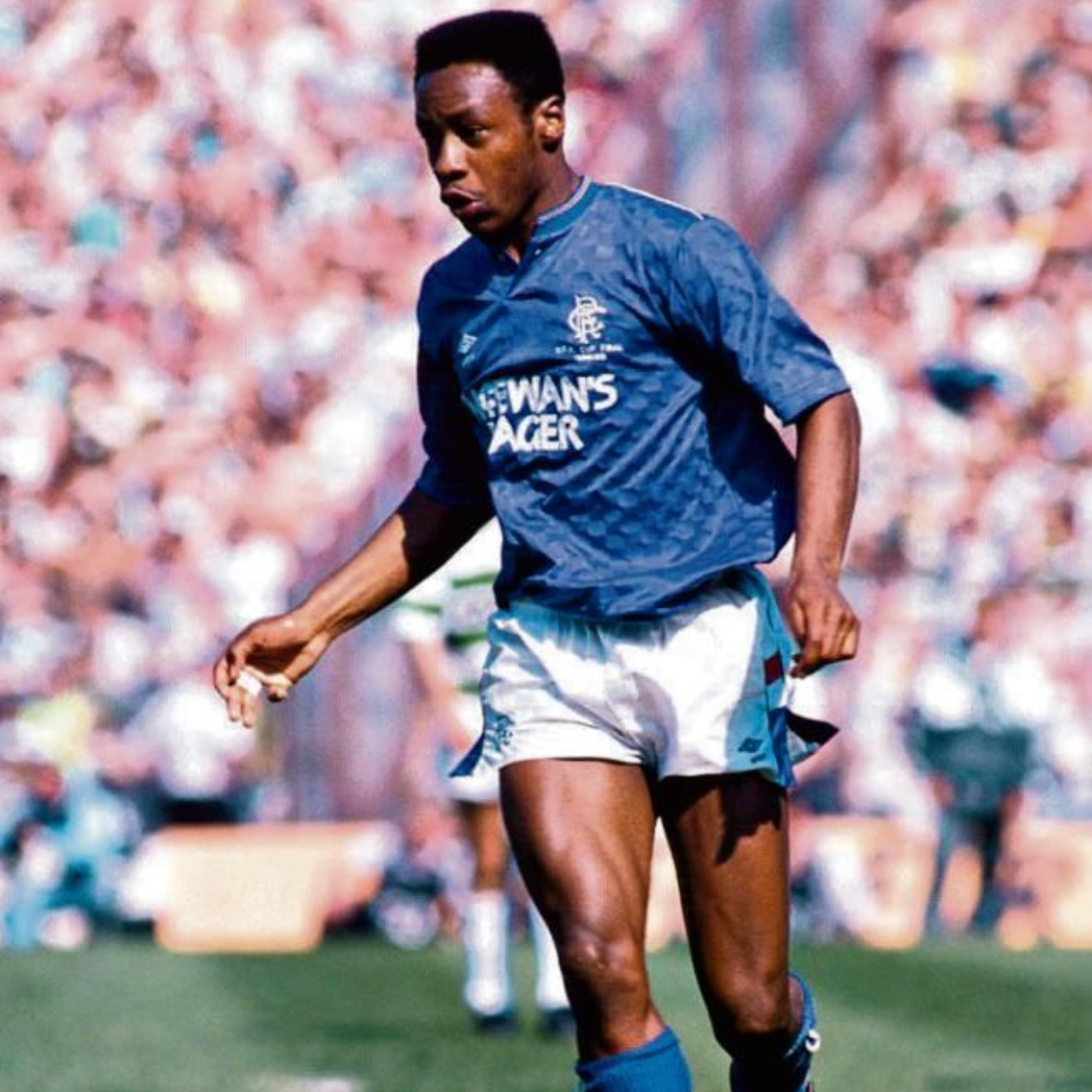 Blue Rangers Home sports jersey from 1987/90 with 'McEwan's Lager' text and Umbro logo on a hanger being worn by Mark Walters during a football match