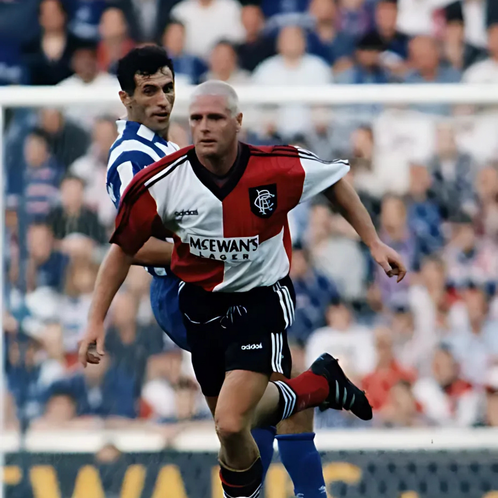 Chequered Red and white Rangers Away football jersey from 1995/96 with Adidas logo and McEwan's Lager branding being worn by Paul Gascoigne during a football match